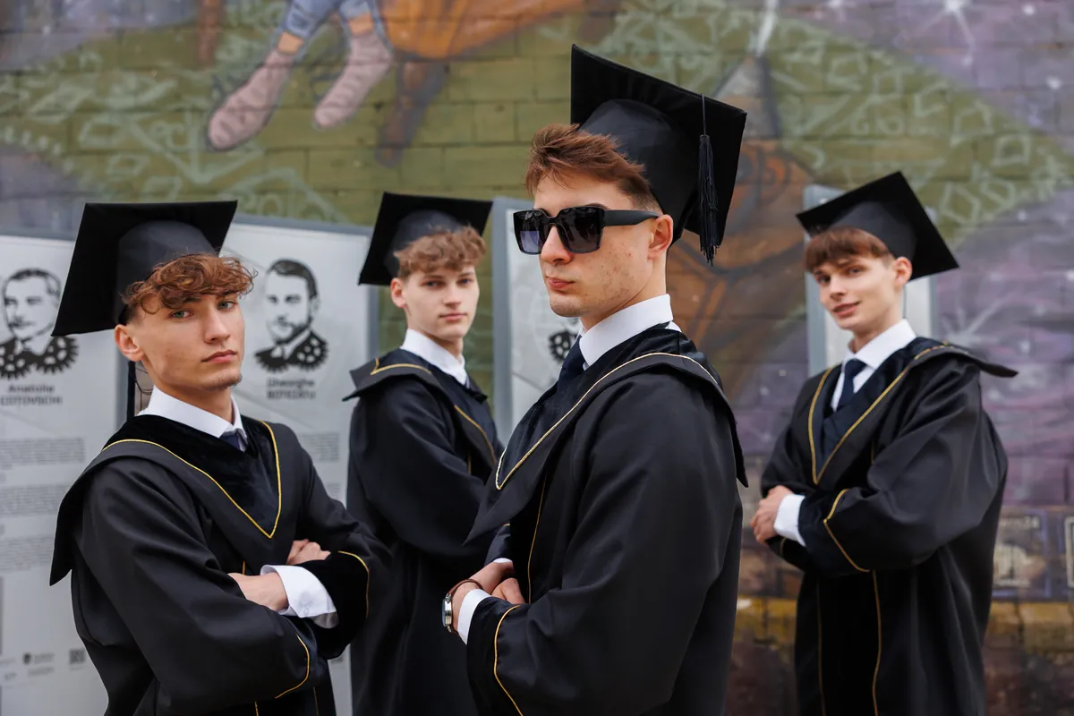 Portret de grup cu absolvenți în mantii și ochelari de soare